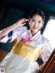 A woman in a white and gold hanbok posing for a picture.