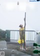 A woman in a yellow dress standing on a pole.