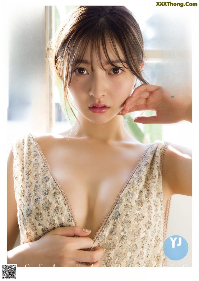 A woman in a white dress is posing for a magazine cover.